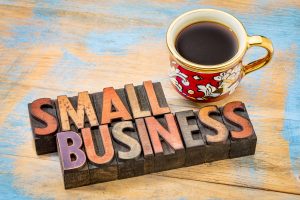 small business in wood blocks with coffee cup and brown background. type